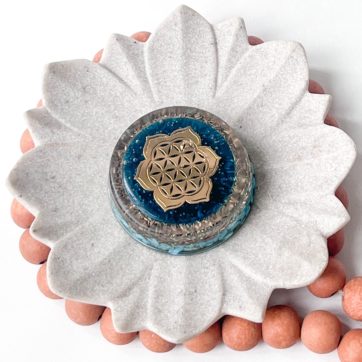 An image of a handmade cylinder orgonite with turquoise stones ,6.5cm diameter by 2.5cm in height - top view