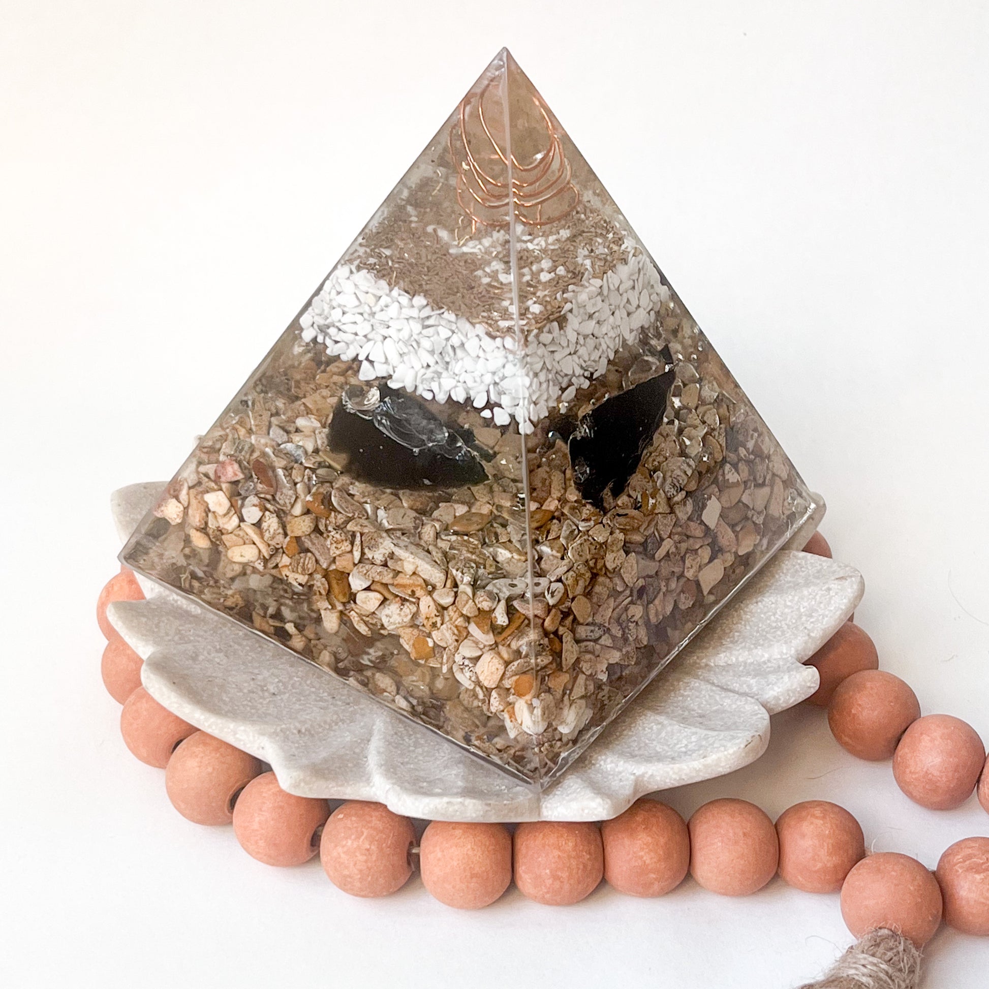 "Elegant orgonite pyramid for clearing negative energy and promoting positivity in your space with arrowheads